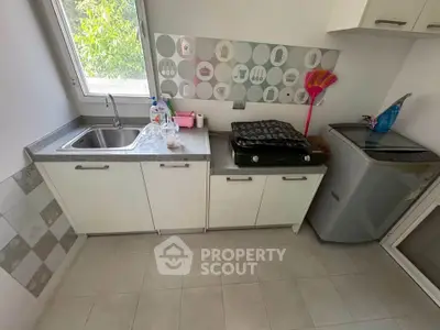Charming kitchen with modern appliances and ample natural light, perfect for culinary enthusiasts.