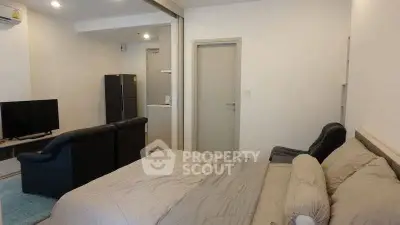 Modern studio apartment with cozy bedroom and living area, featuring sleek furniture and neutral tones.