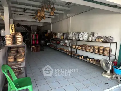 Spacious storage area with shelves displaying decorative wooden items and a fan.