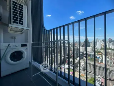 Stunning city view from high-rise balcony with washing machine and air conditioning unit.