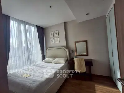 Cozy bedroom with elegant decor and city view, featuring a comfortable bed and stylish furniture.