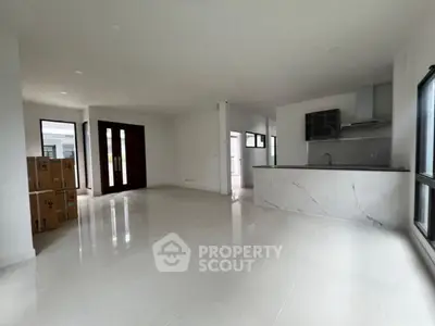 Spacious modern living area with open kitchen and large windows in a new home.