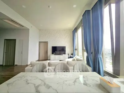 Luxurious living room with panoramic windows and elegant decor in high-rise apartment.