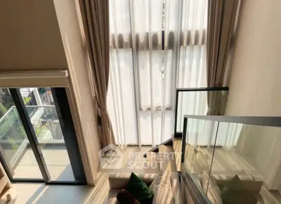 Luxurious high-ceiling living room with floor-to-ceiling windows and balcony access