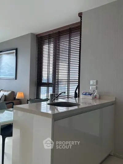 Modern kitchen with sleek island and large windows in a stylish apartment.