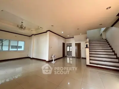 Spacious living room with elegant staircase and chandelier in modern home