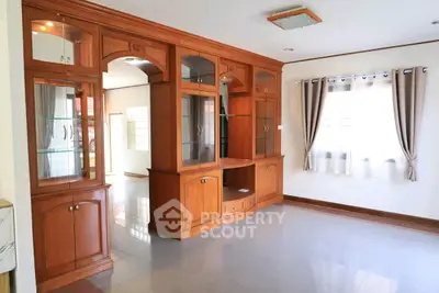 Spacious living room with elegant wooden cabinetry and large windows