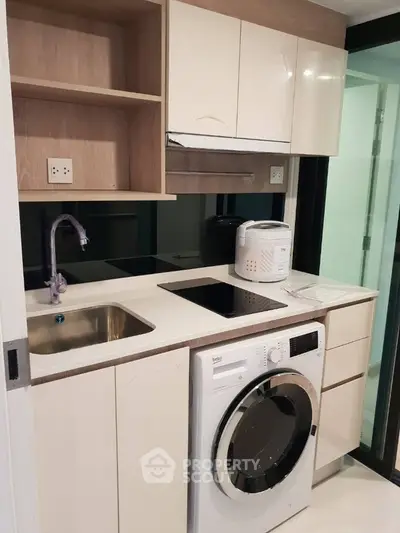 Modern compact kitchen with washing machine and sleek cabinetry