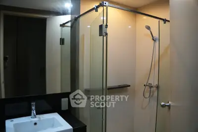Modern bathroom with glass shower enclosure and sleek fixtures