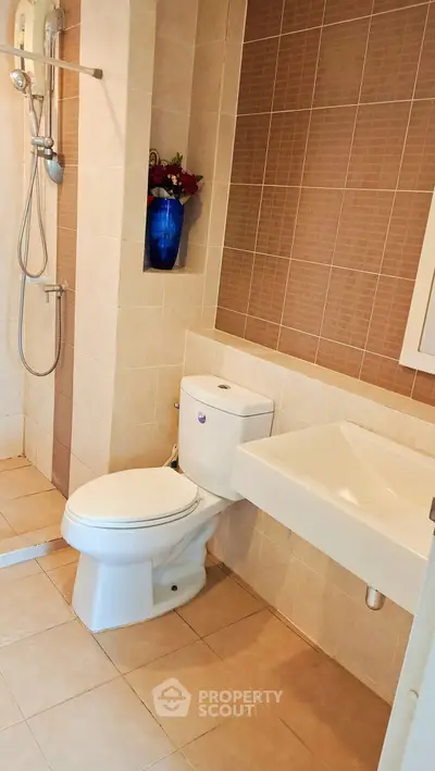 Modern bathroom with sleek fixtures and stylish tile design, featuring a shower and toilet.