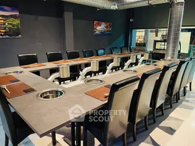 Modern dining area with unique table design and sleek black chairs in a stylish restaurant setting.