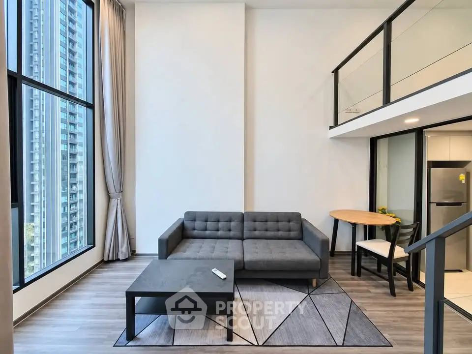 Modern loft apartment with high ceilings and large windows, featuring a stylish living area and mezzanine.