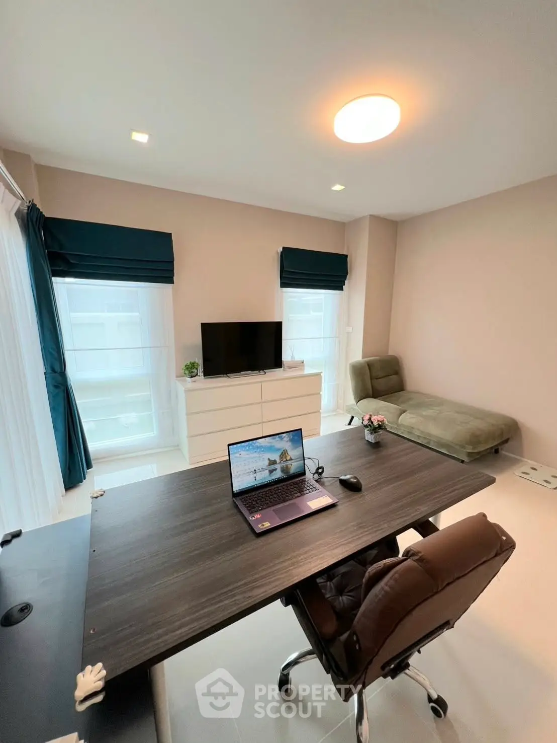Modern study room with sleek desk, comfortable chair, and natural light from large windows.