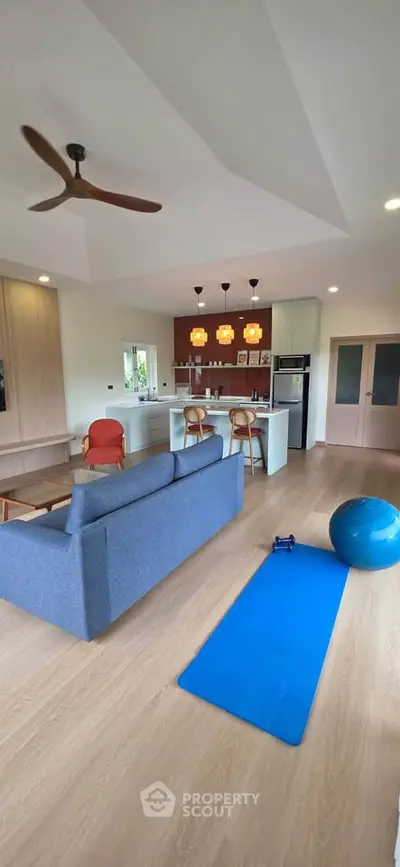 Spacious open-plan living room with modern kitchen and exercise area
