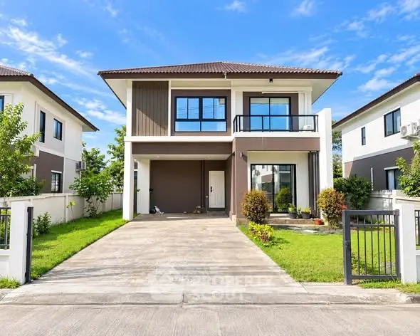 Modern two-story house with driveway and lush green lawn in a serene neighborhood.