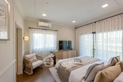 Spacious bedroom with modern decor and natural light, featuring a cozy reading nook.