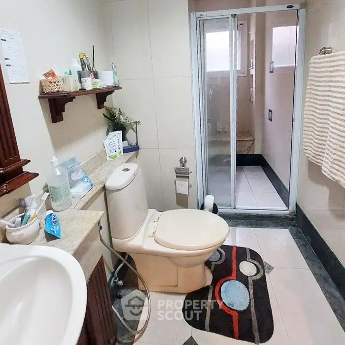 Modern bathroom with shower and stylish decor, featuring a sleek toilet and elegant sink.