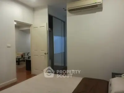 Cozy bedroom with air conditioning and view into living area, perfect for comfortable living.
