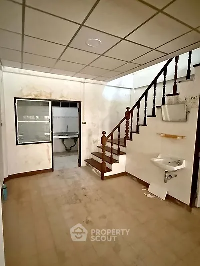 Spacious interior with staircase and sink, ideal for renovation projects.