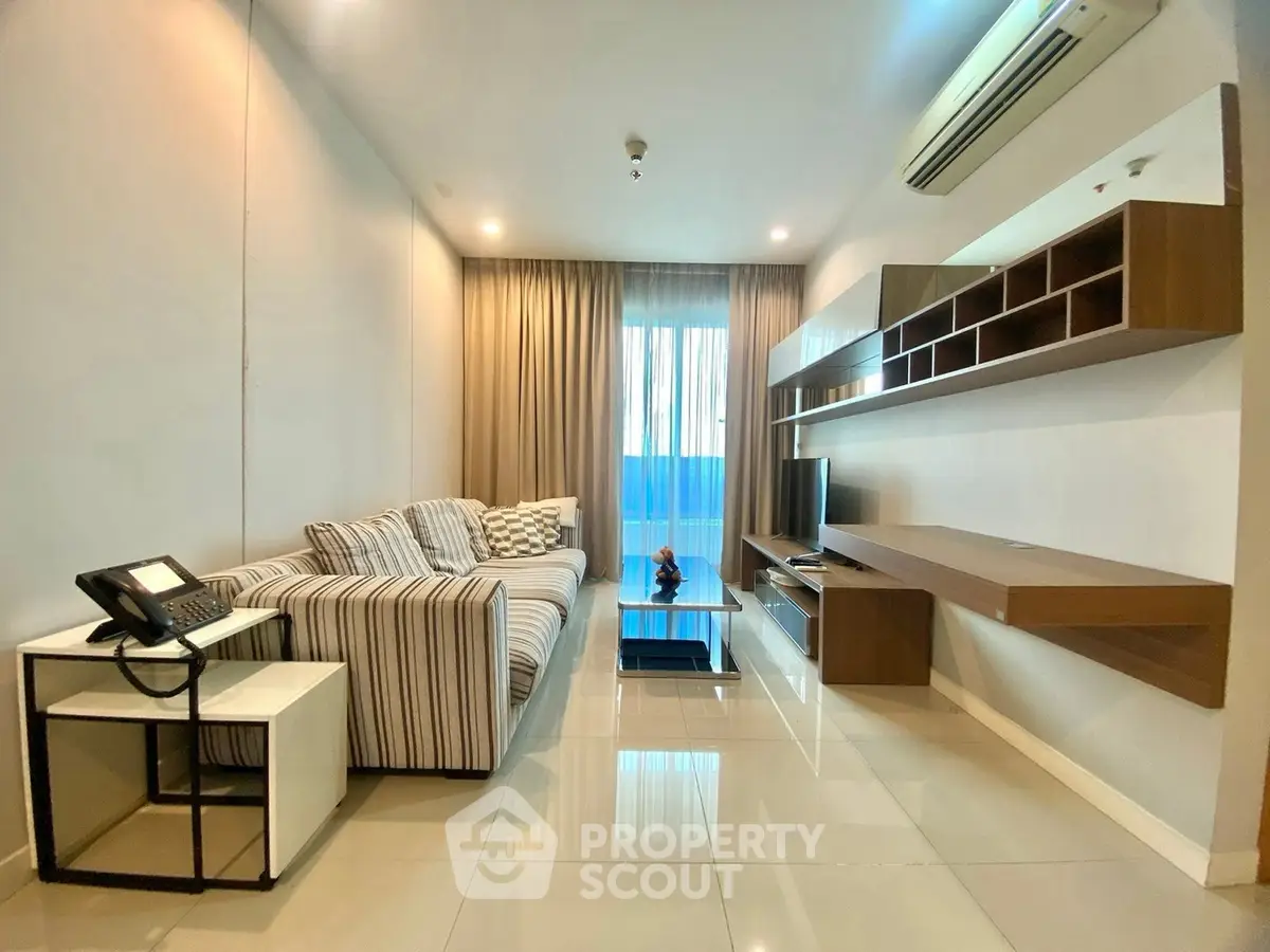 Modern living room with sleek furniture and natural light, featuring a cozy sofa and wall-mounted shelves.