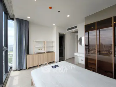 Modern bedroom with city view, featuring sleek furniture and large windows.
