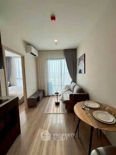 Modern living room with cozy dining area and natural light in stylish apartment.