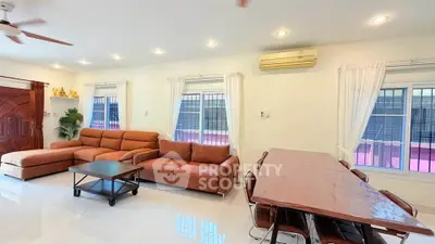 Spacious living room with modern furniture and large windows in a bright, airy home.