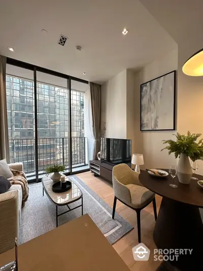 Elegant living room with modern furnishings, large windows, and balcony access, perfect for urban living and entertaining guests.