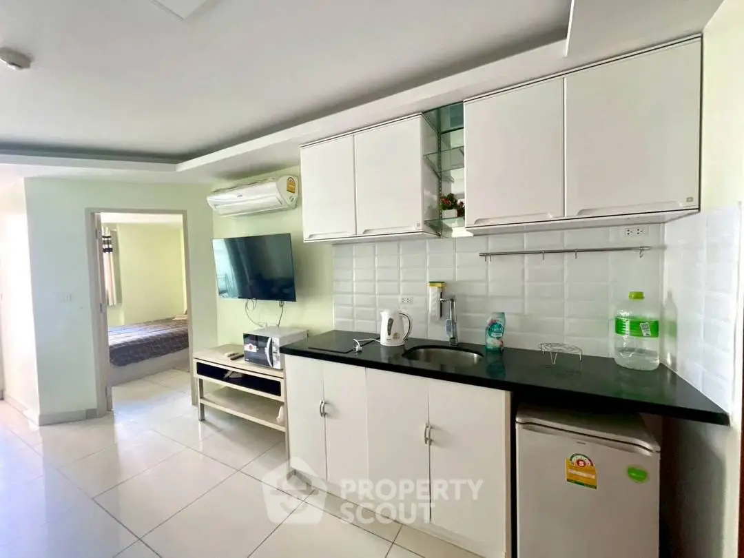 Modern kitchen with sleek cabinets and appliances in a bright apartment interior.