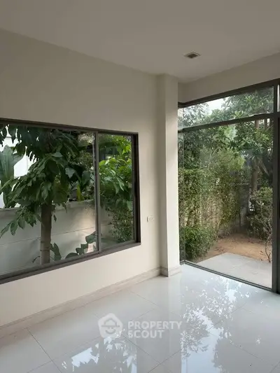 Bright interior space with large windows and garden view, perfect for natural light lovers.