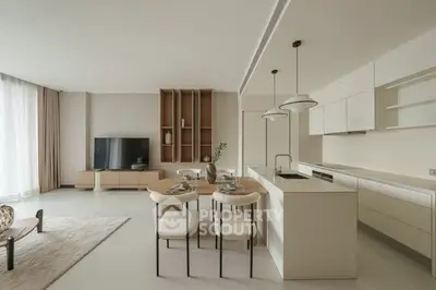 Modern open-layout living room and kitchen with sleek design and neutral tones.