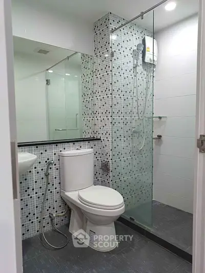 Modern bathroom with glass shower and mosaic tile accent wall