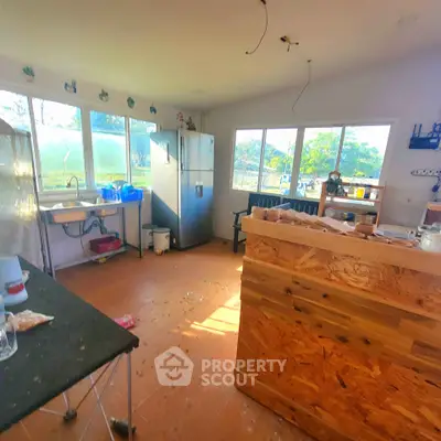 Spacious kitchen with large windows and modern appliances, perfect for culinary enthusiasts.