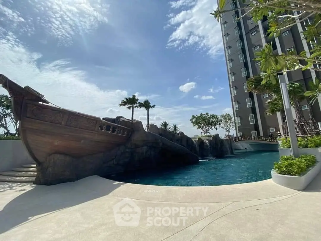 Luxurious apartment complex with stunning pool and unique ship-themed design under a clear blue sky.