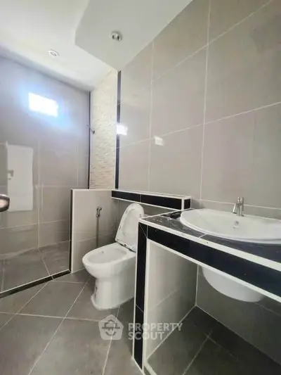 Modern bathroom with sleek tiles and contemporary fixtures in a stylish real estate property.