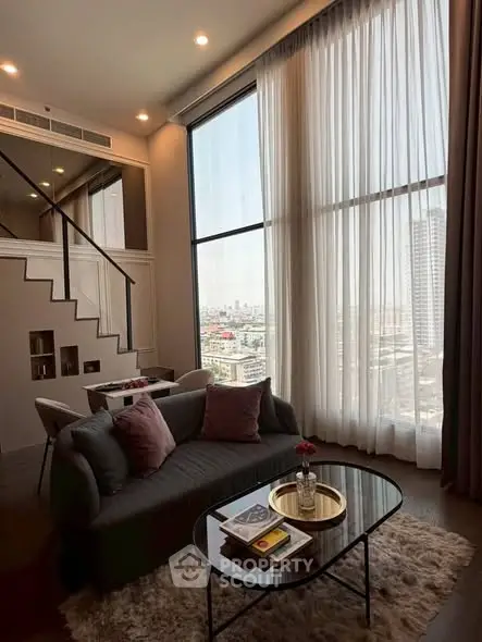 Luxurious living room with high ceilings and panoramic city view, featuring elegant decor and cozy seating area.