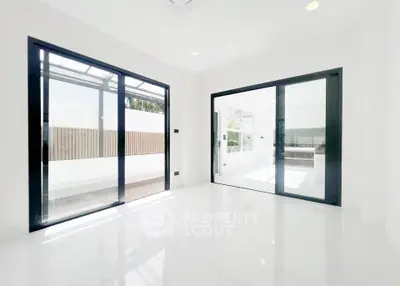 Bright modern interior with large sliding glass doors and white marble flooring, perfect for natural light lovers.