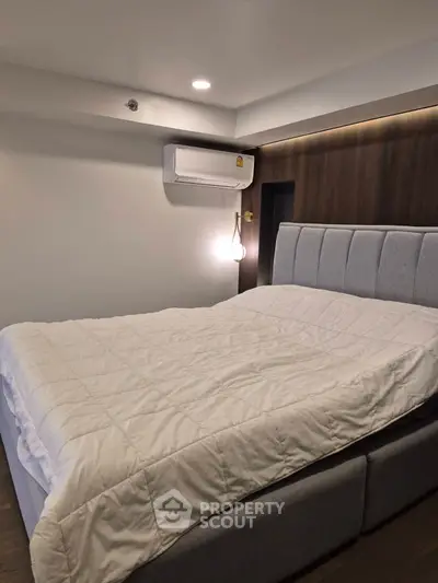 Modern bedroom with stylish bed and air conditioning unit, perfect for comfort and relaxation.
