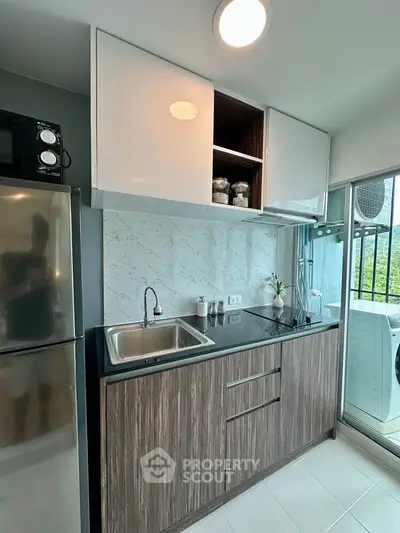 Modern kitchen with sleek cabinetry, stainless steel appliances, and a scenic view from the window.