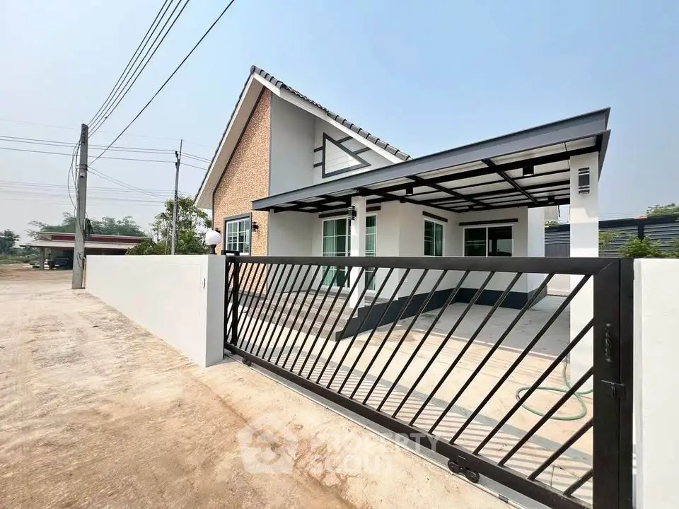 Modern single-story house with gated entrance and spacious driveway