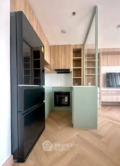 Modern kitchen with sleek appliances and stylish cabinetry in a contemporary apartment.