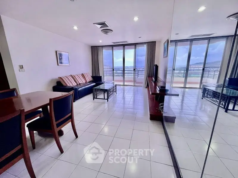 Spacious living room with large windows and balcony offering stunning views.
