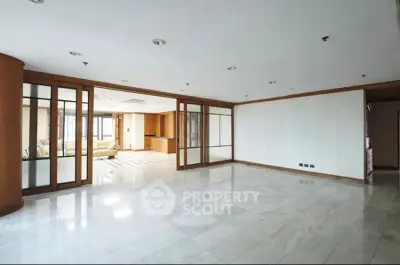Spacious open-plan living room with sliding glass doors and marble flooring in modern apartment.