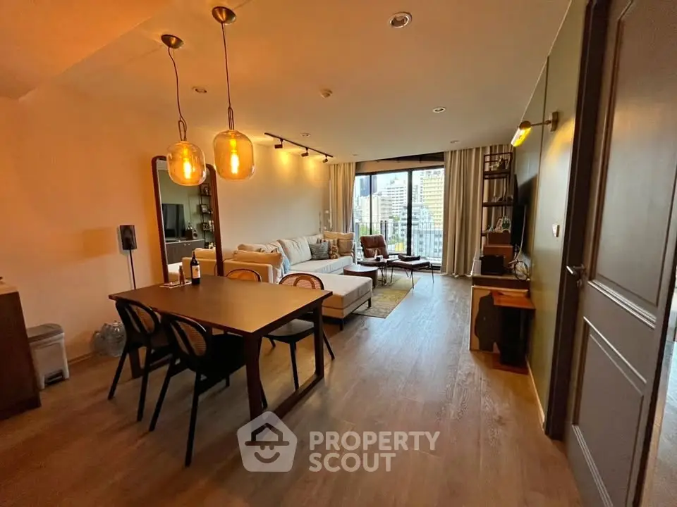 Spacious living room with modern decor and city view, featuring elegant lighting and cozy seating area.