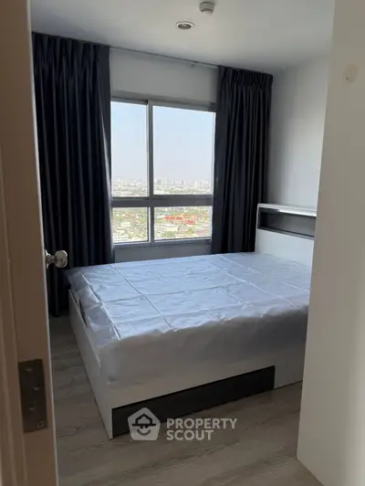 Modern bedroom with large window offering stunning city view, featuring sleek design and ample natural light.