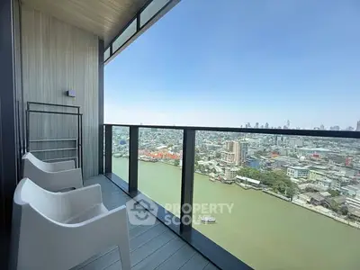 Stunning high-rise balcony with panoramic city and river views, perfect for relaxation and enjoying the skyline.
