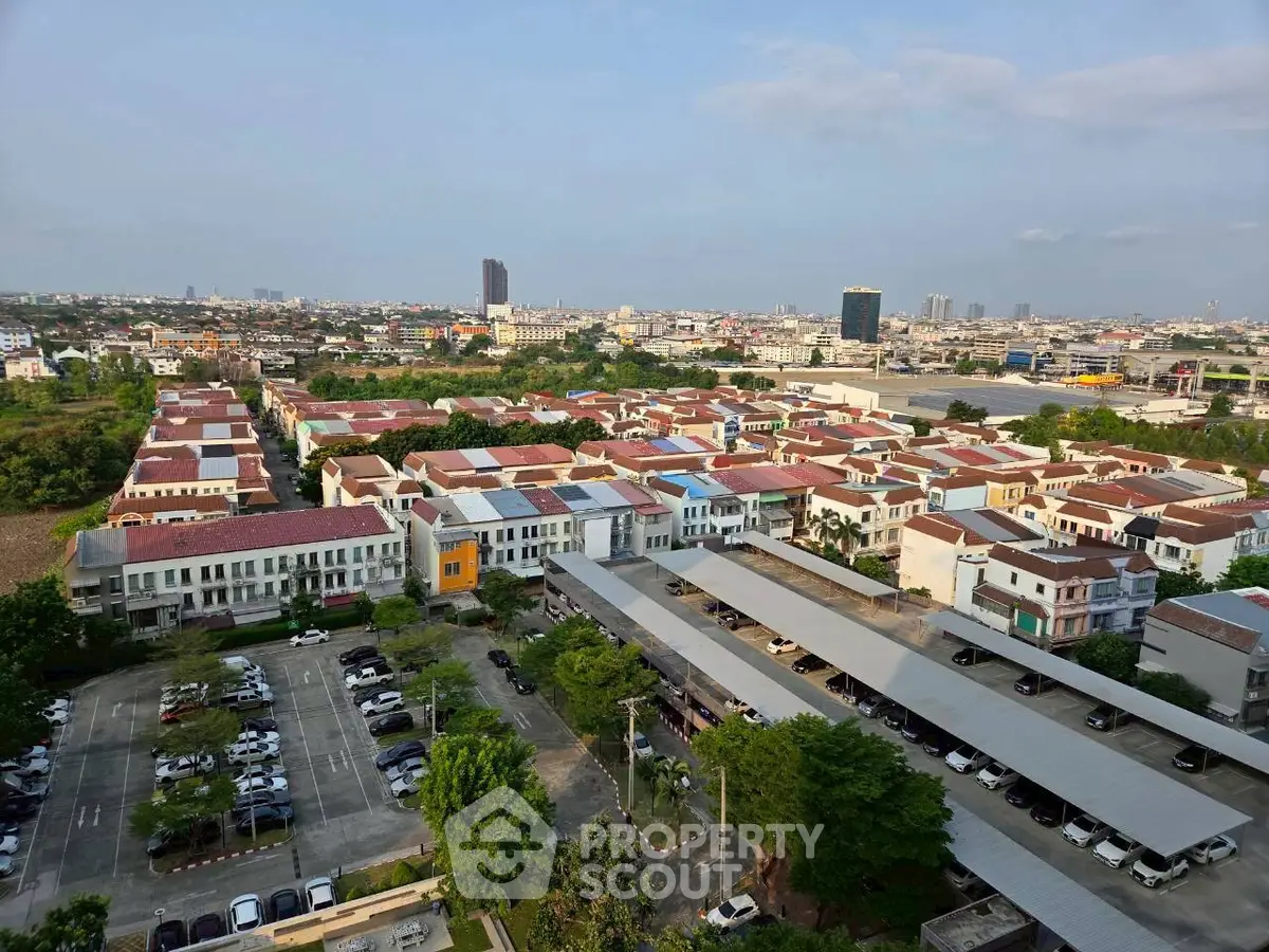 Aerial view of a residential neighborhood with rows of houses and parking area.