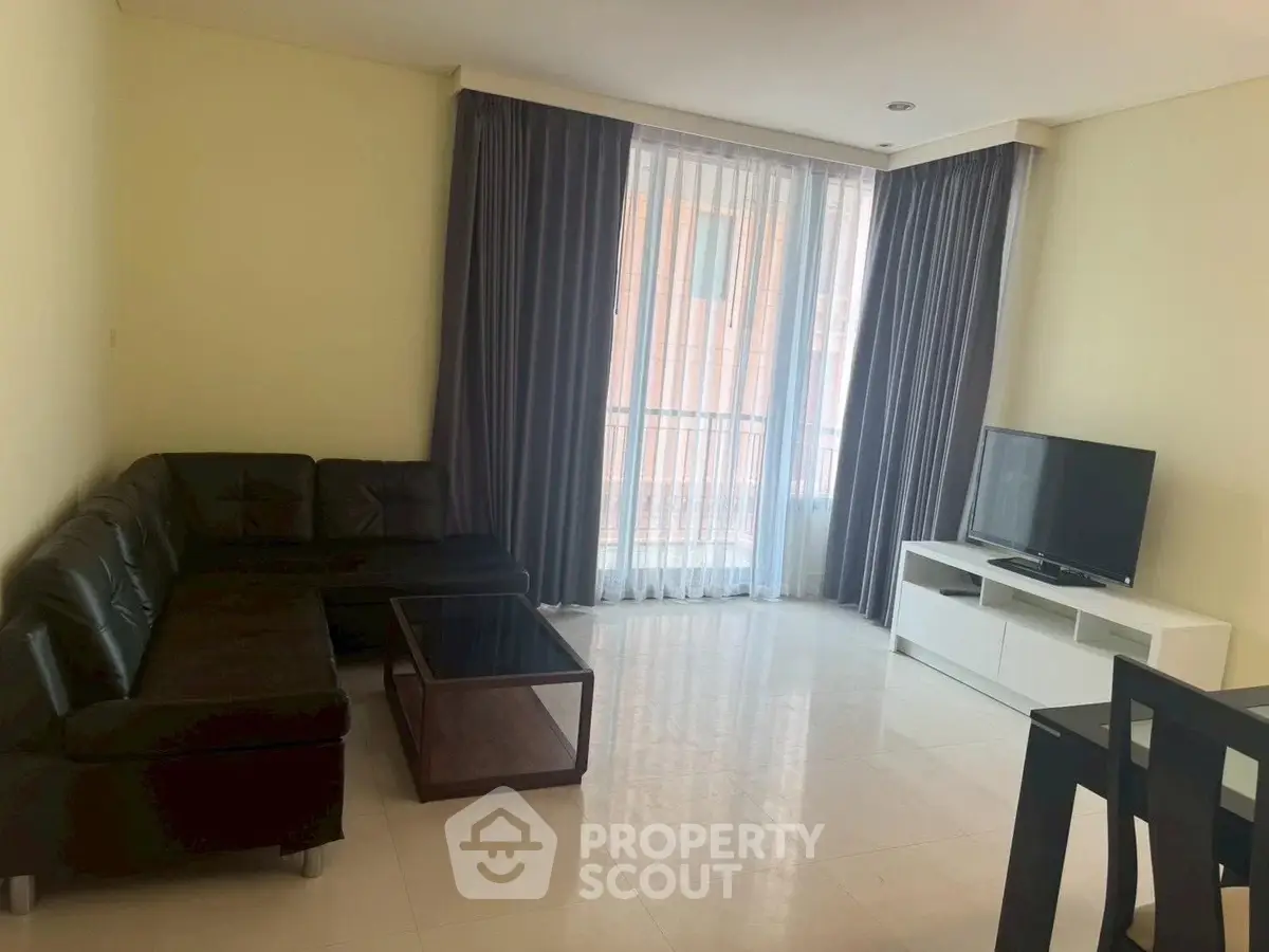 Spacious living room with modern furniture and large window in a stylish apartment.