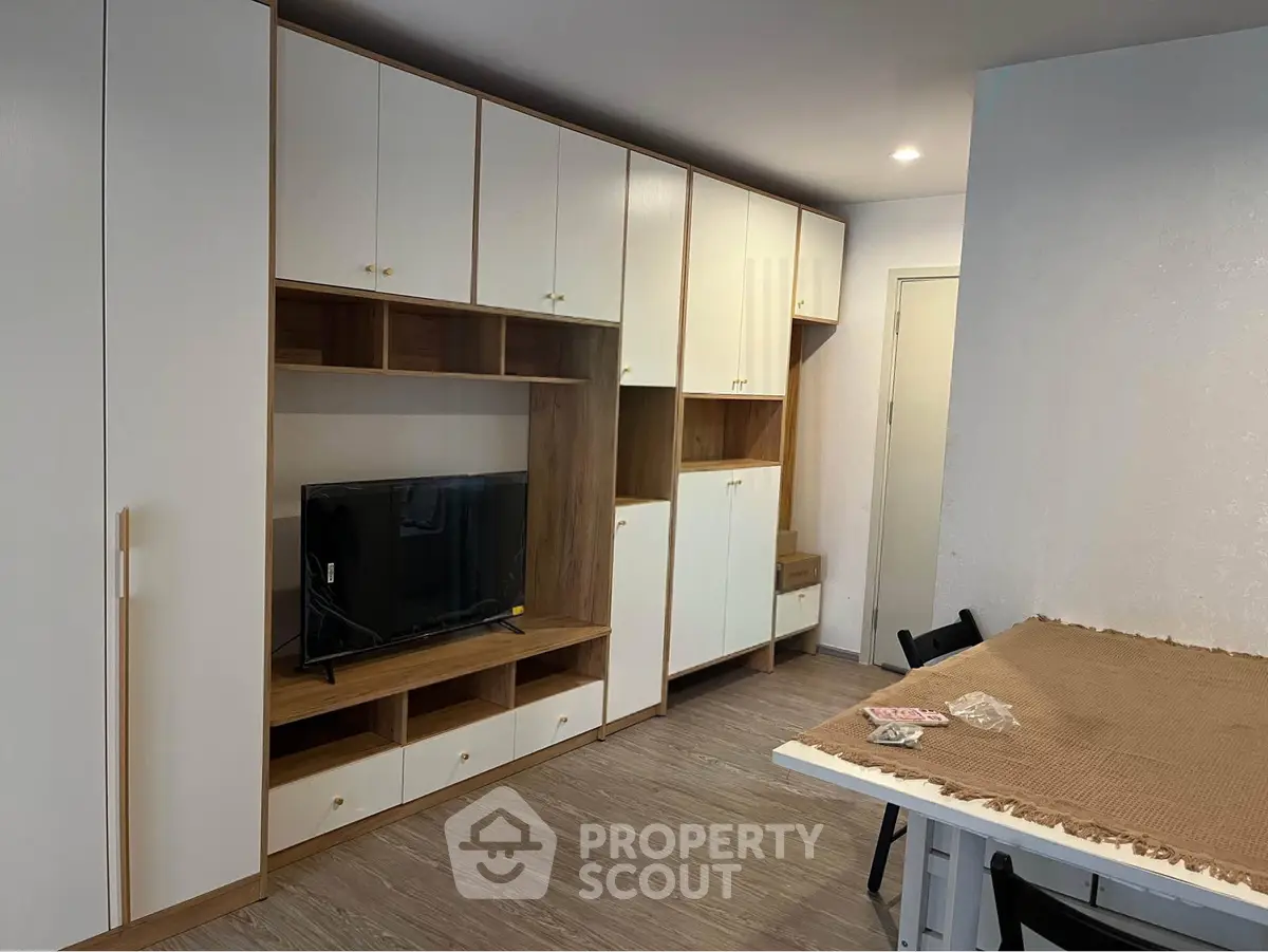 Modern living room with built-in storage and TV unit, featuring sleek design and ample space.