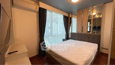 Cozy bedroom with large windows and modern decor in a stylish apartment.